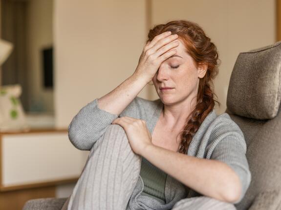 Thoughtful middle-aged woman with long red hair – a moment of self-reflection at Park Igls Medical Spa Resort