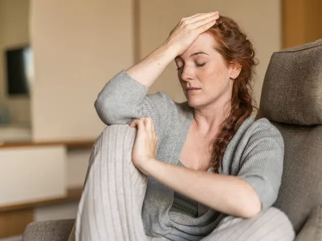 Nachdenkliche Frau mit langen roten Haaren – Moment der Selbstreflexion im Park Igls Medical Spa Resort