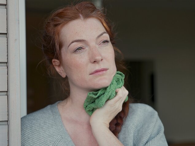 Thoughtful middle-aged woman with long red hair – a moment of self-reflection at Park Igls Medical Spa Resort