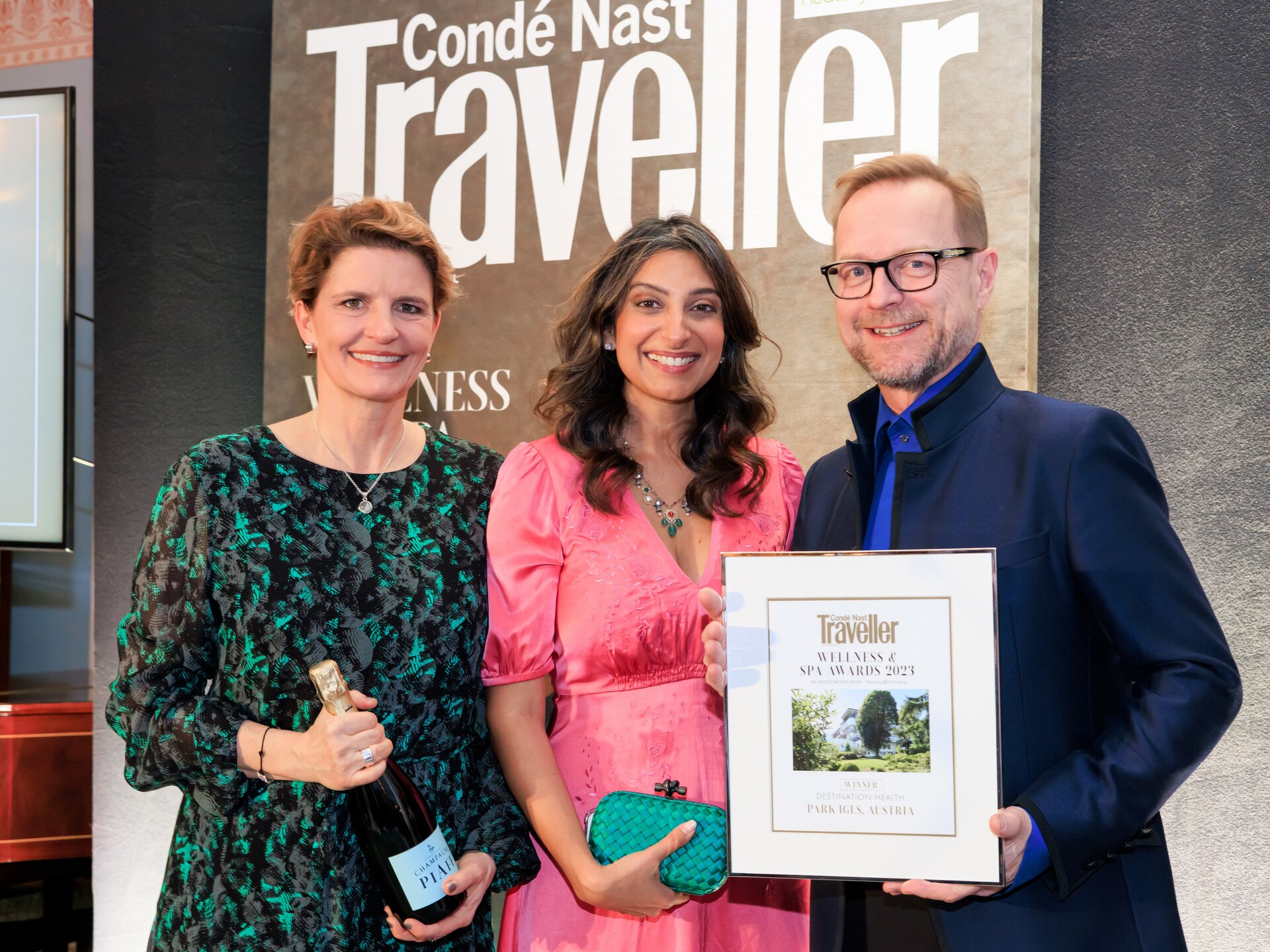 Drei Personen präsentieren stolz eine Auszeichnung vor einem Condé Nast Traveller Banner