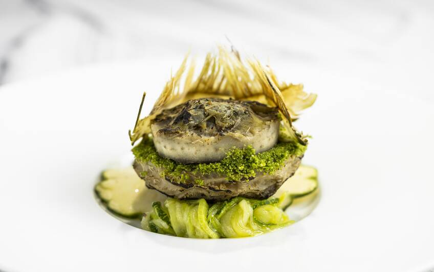 Gefüllte Artischocke mit Zitrone-Mayonnaise, Artischocken-Chips und Mini-Patisson-Kürbis auf Teller