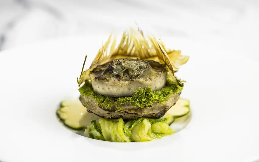 Gefüllte Artischocke mit Zitrone-Mayonnaise, Artischocken-Chips und Mini-Patisson-Kürbis auf Teller