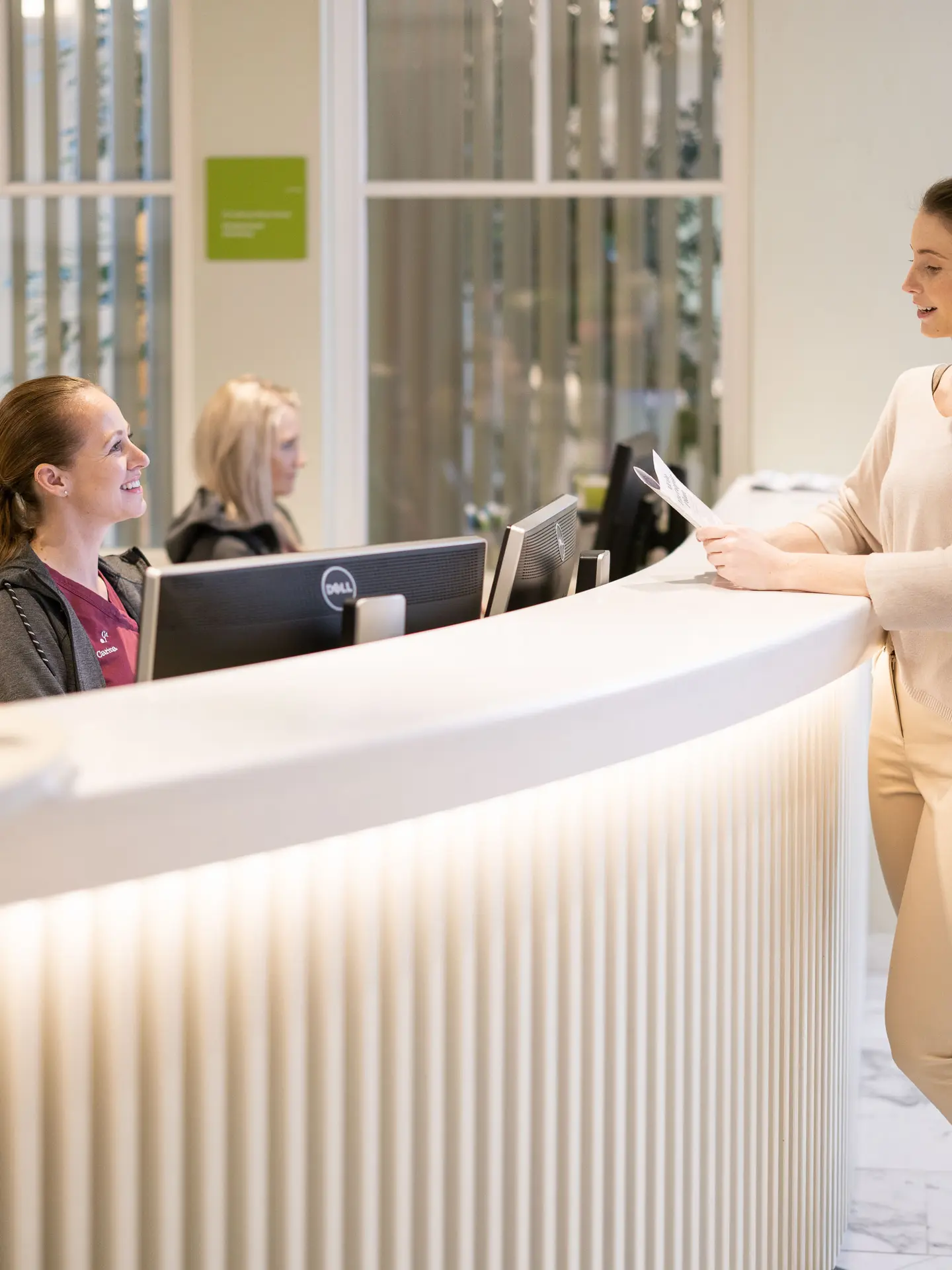 A young woman checks in at the reception of Park Igls