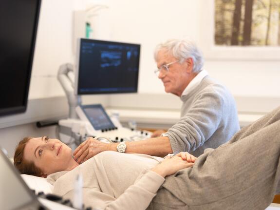 Frau bei einer Ultraschalluntersuchung der Halsschlagader in Rückenlage