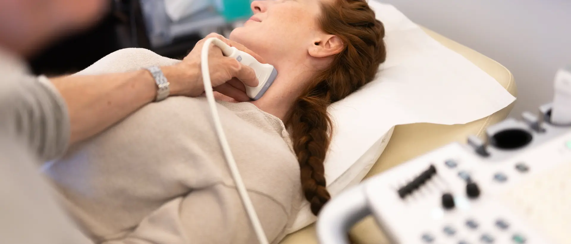 Frau bei einer Ultraschalluntersuchung der Halsschlagader in Rückenlage
