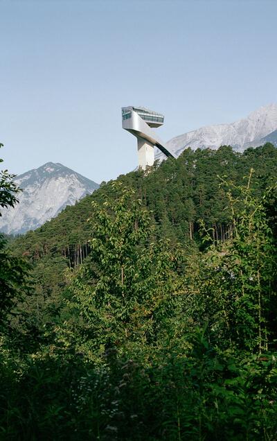 The Bergisel Ski Jump in Innsbruck rises above forested slopes | © Tirol Werbung / George Marshall