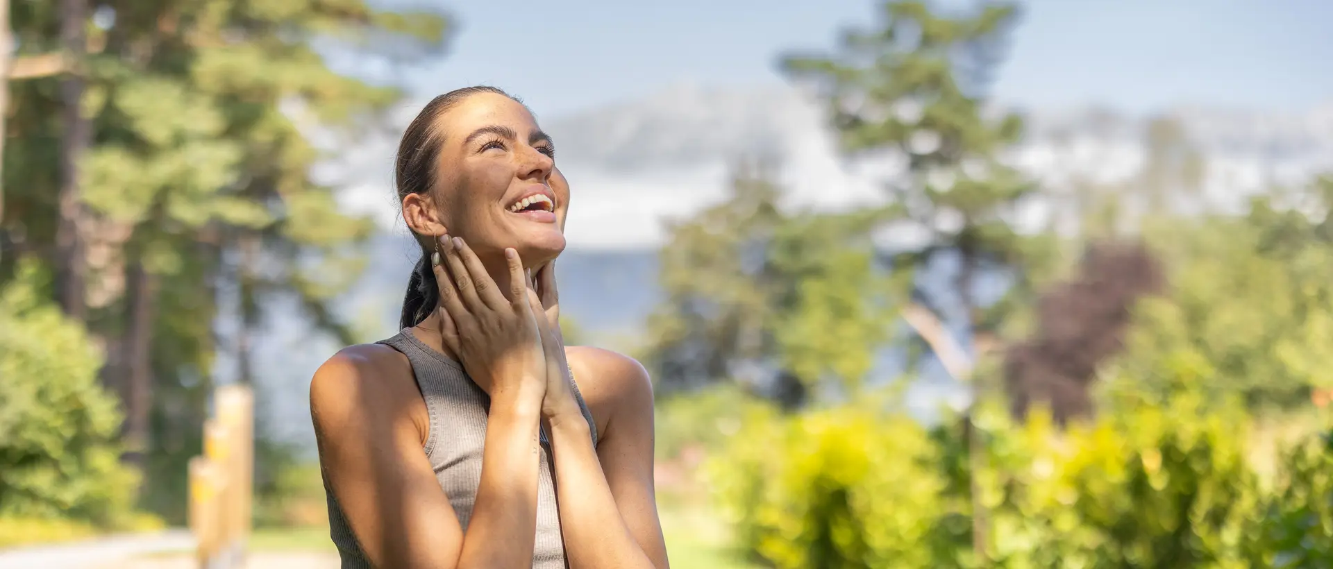 Junge Frau genießt Sonne im Garten des Park Igls