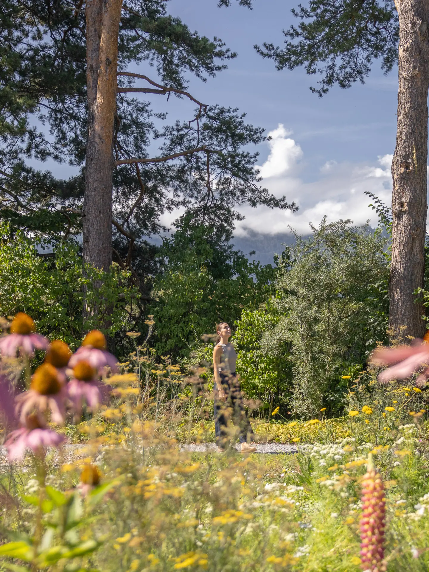 Junge Frau genießt Sonne im Garten des Park Igls