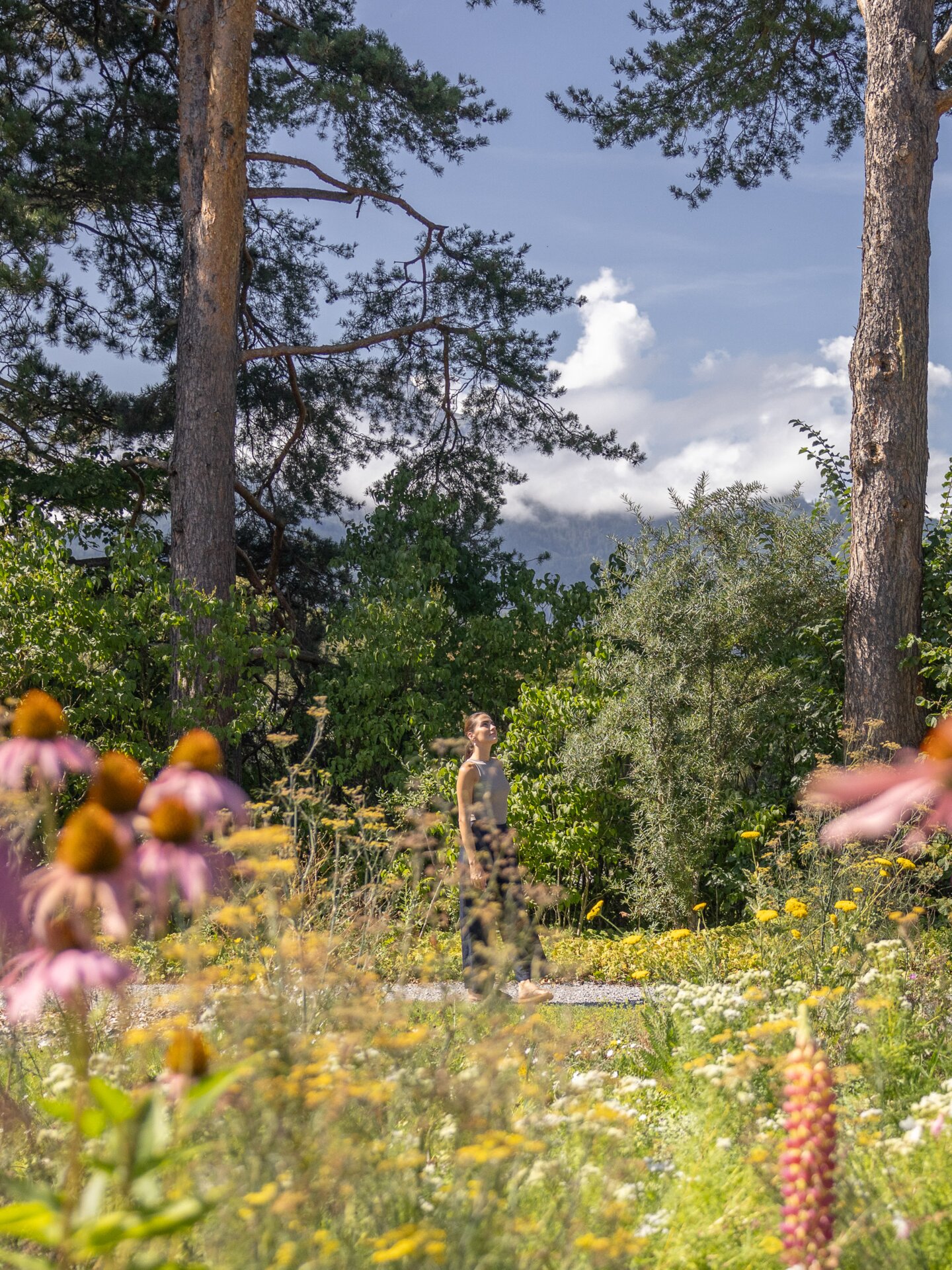 Junge Frau genießt Sonne im Garten des Park Igls