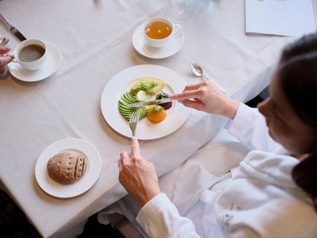 Frau im Bademantel isst gesund