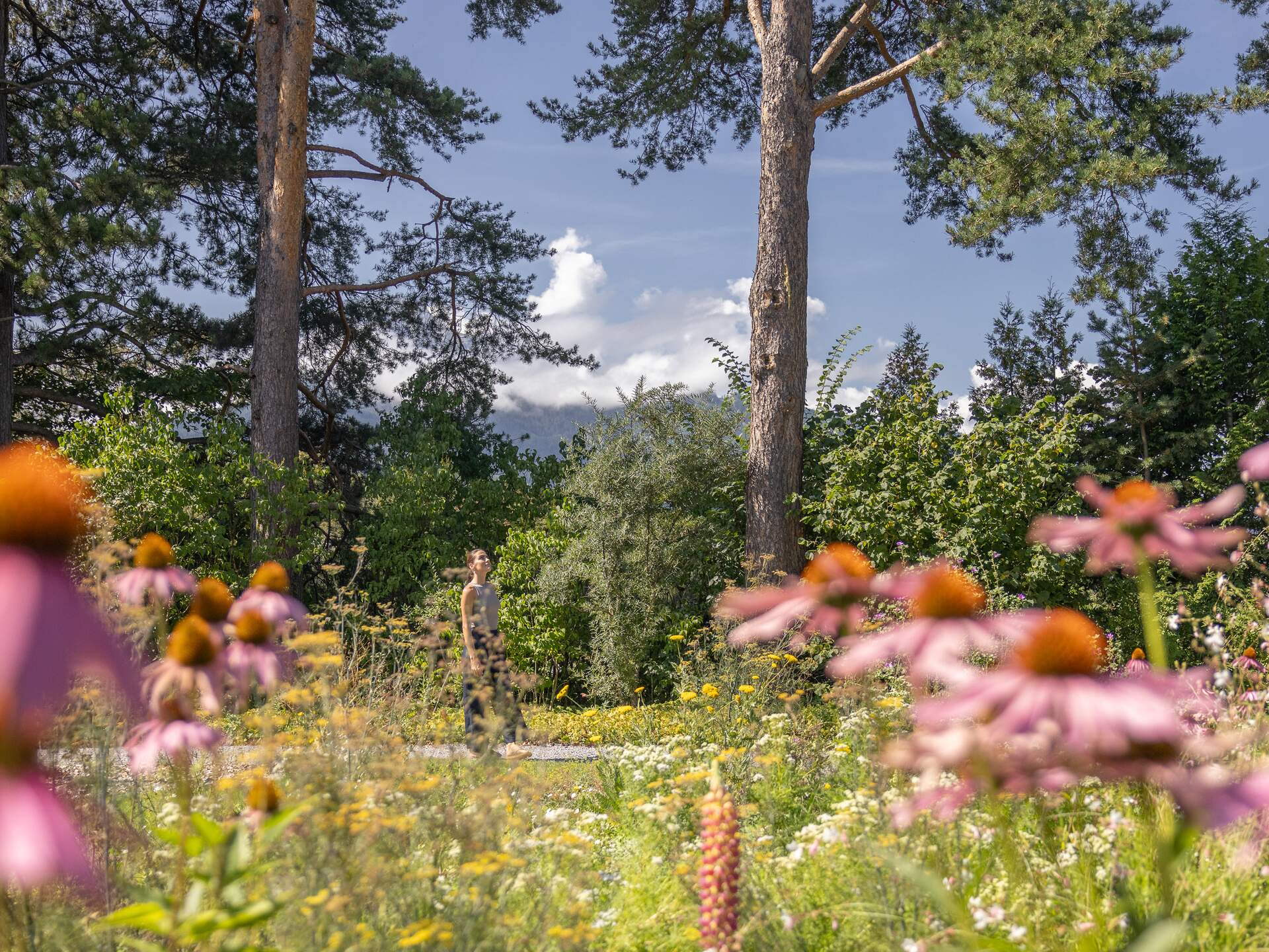 Junge Frau genießt Sonne im Garten des Park Igls